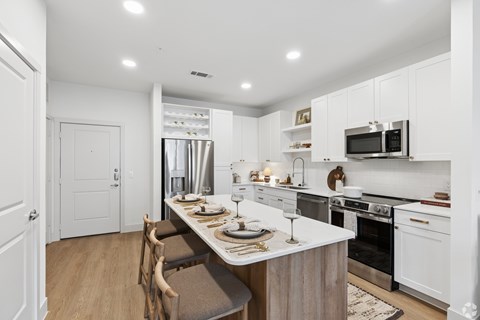 A modern kitchen with a dining table set for two.