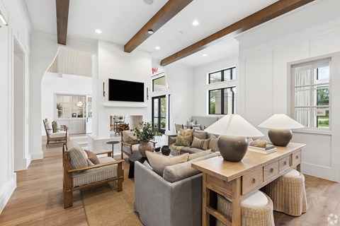 A living room with a grey couch, a wooden table, and a television.