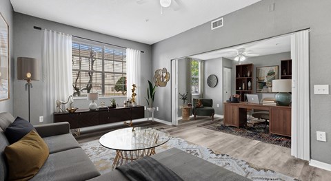 A modern living room with a grey sofa and a glass coffee table.
