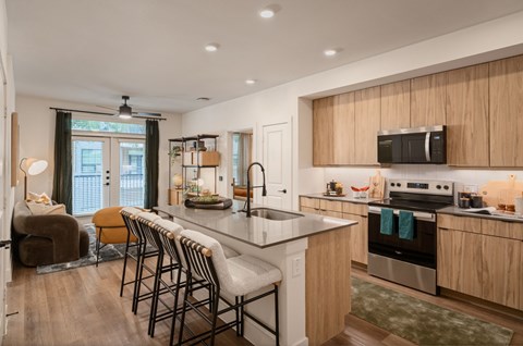 A kitchen with a large island and bar stools.