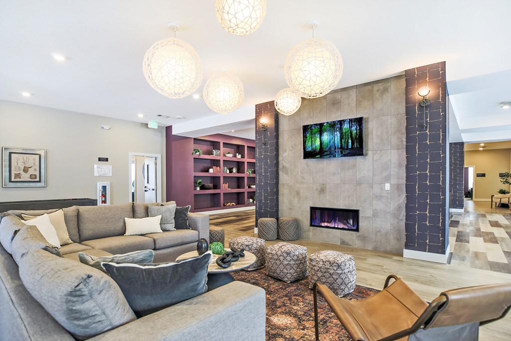A living room with a grey couch and a fireplace.