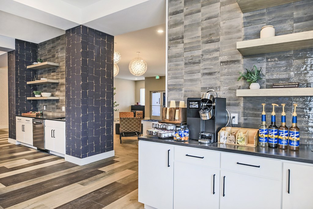 A kitchen with a black and white theme and a wooden floor.