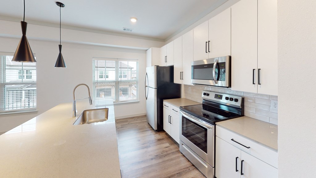 a kitchen with white cabinets and stainless steel appliances