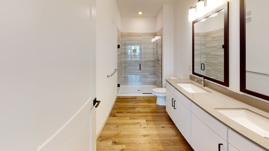 A long, narrow hallway with a toilet and sink visible.