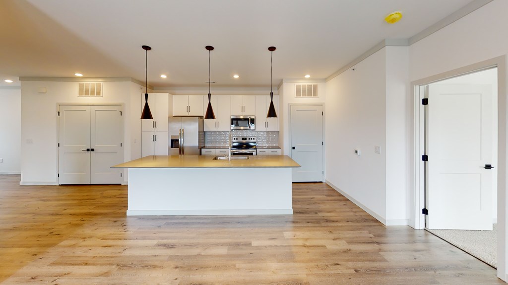 A kitchen with a wooden floor and white walls.