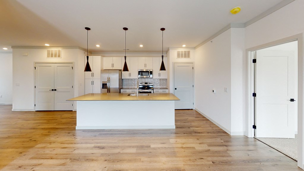 a kitchen with white cabinets and a large island with a wooden countertop
