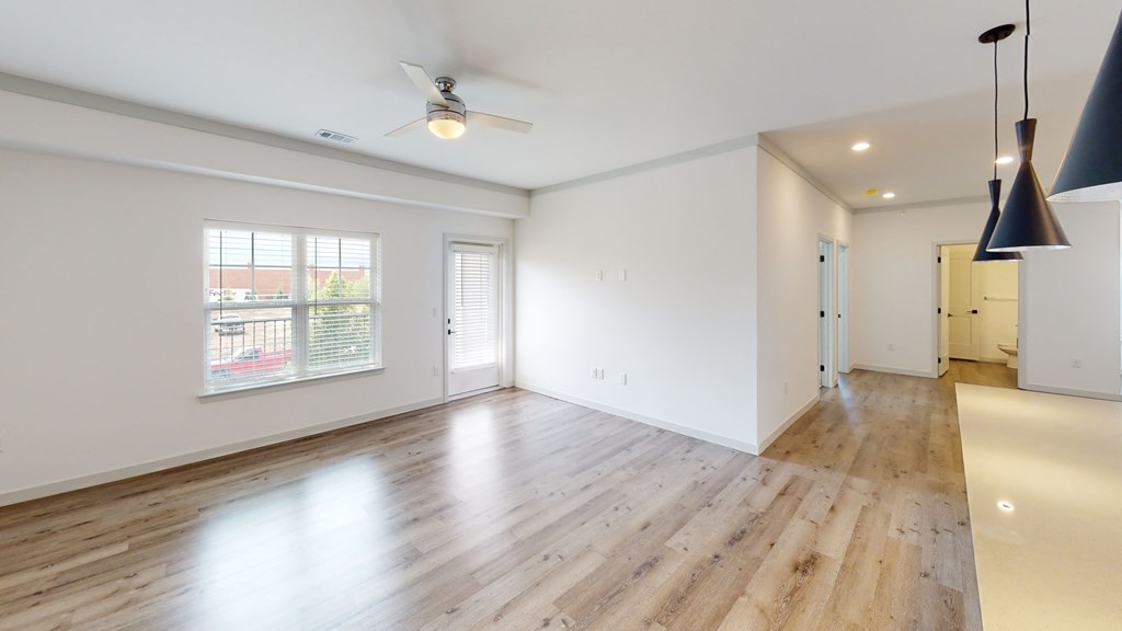 a living room with hardwood floors and white walls