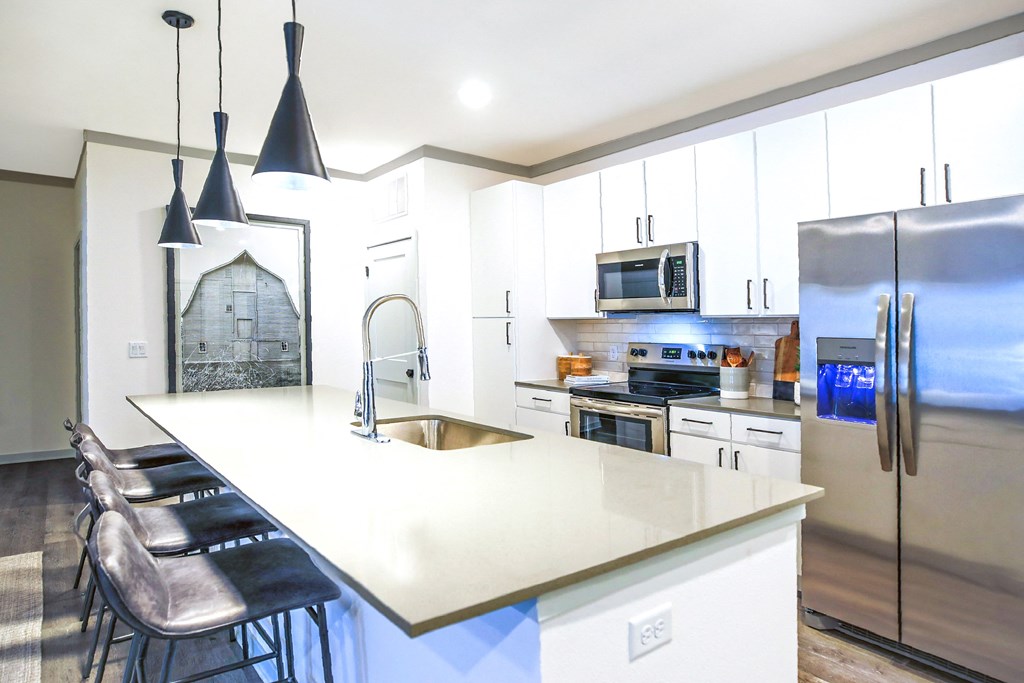 a modern kitchen with white cabinets and stainless steel appliances