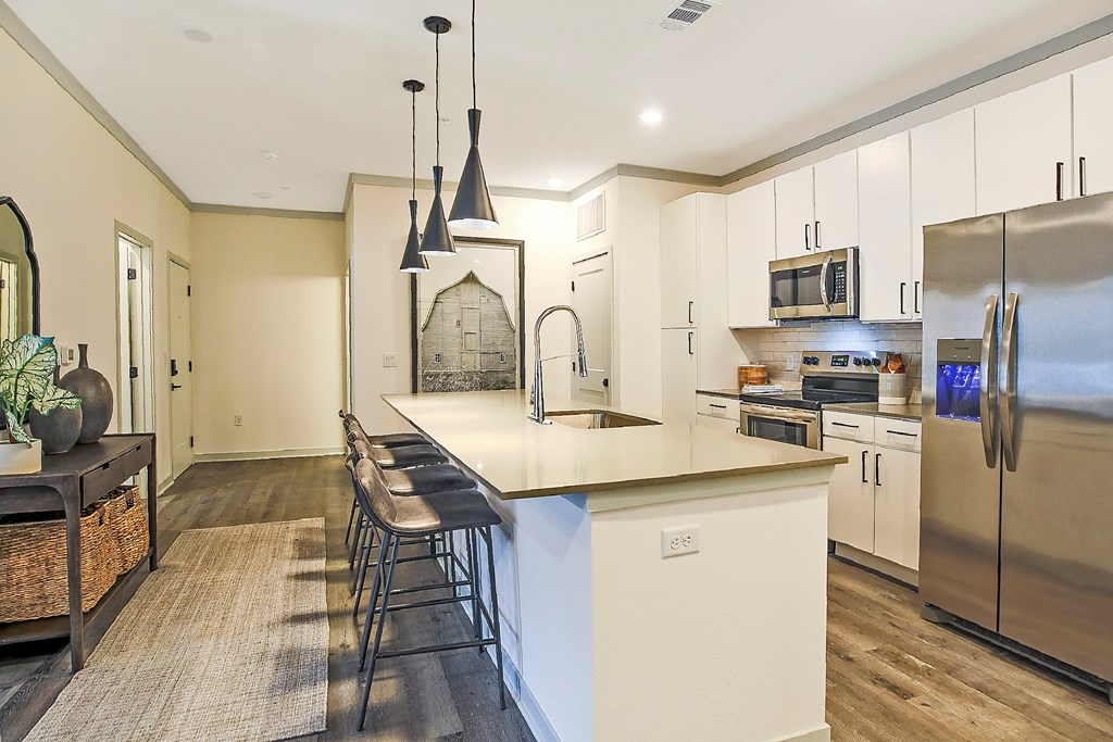 A kitchen with a white island and stainless steel appliances.