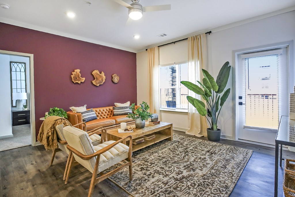 A living room with a sofa, chair, and potted plants.