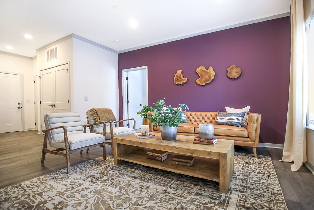 A living room with a purple wall and a wooden coffee table.