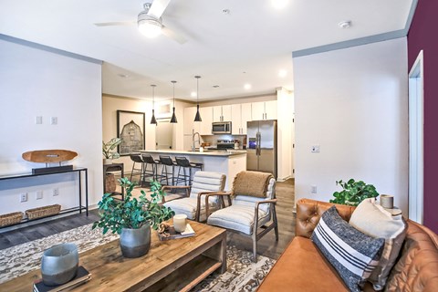 a living room and kitchen with a couch and chairs and a table