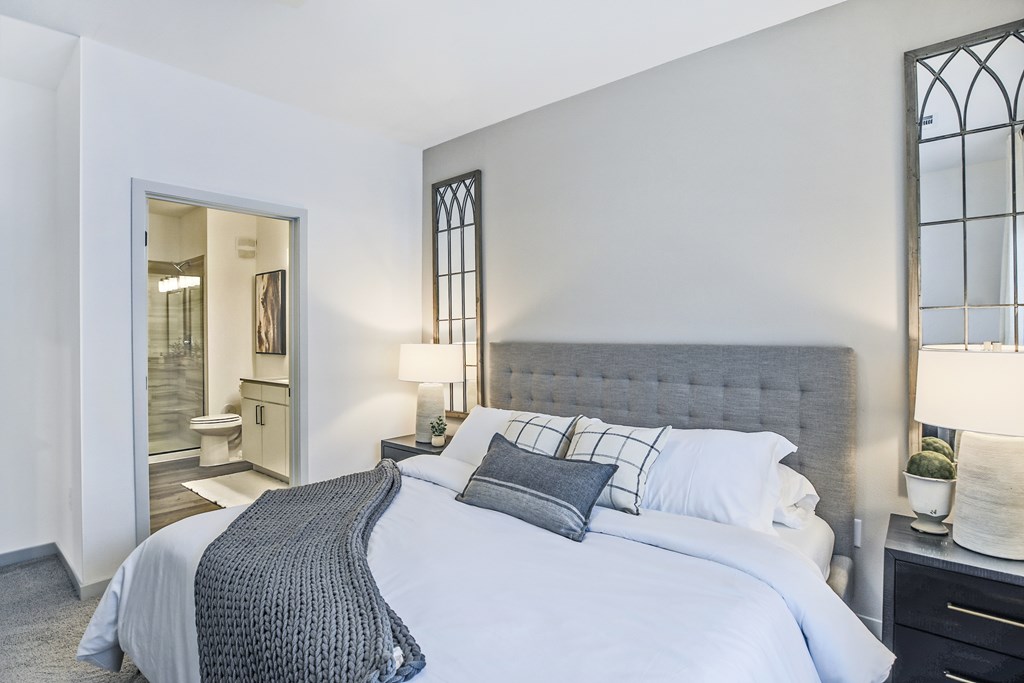 A bedroom with a large bed and a window with bars.