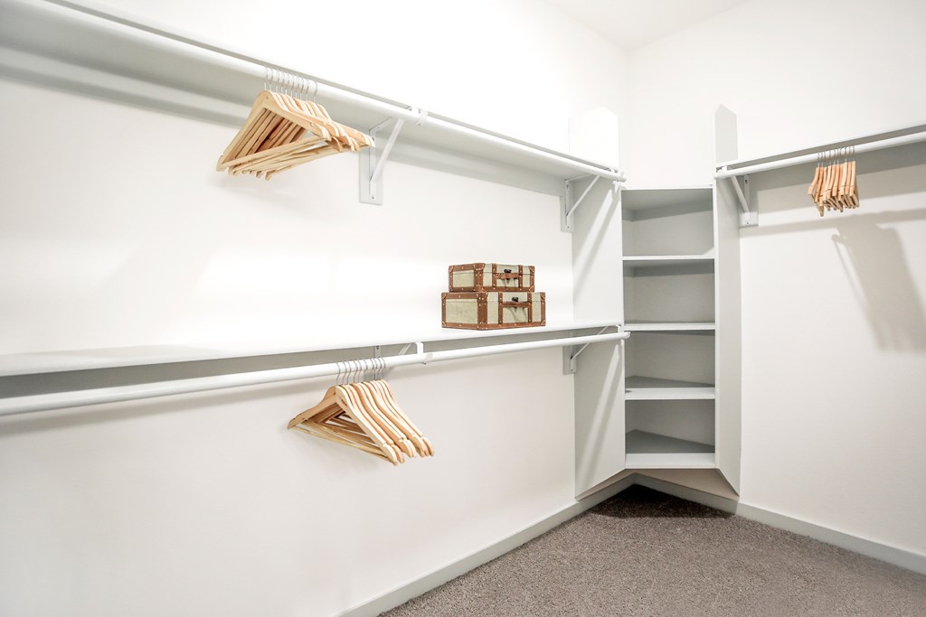 A white closet with shelves and hangers.