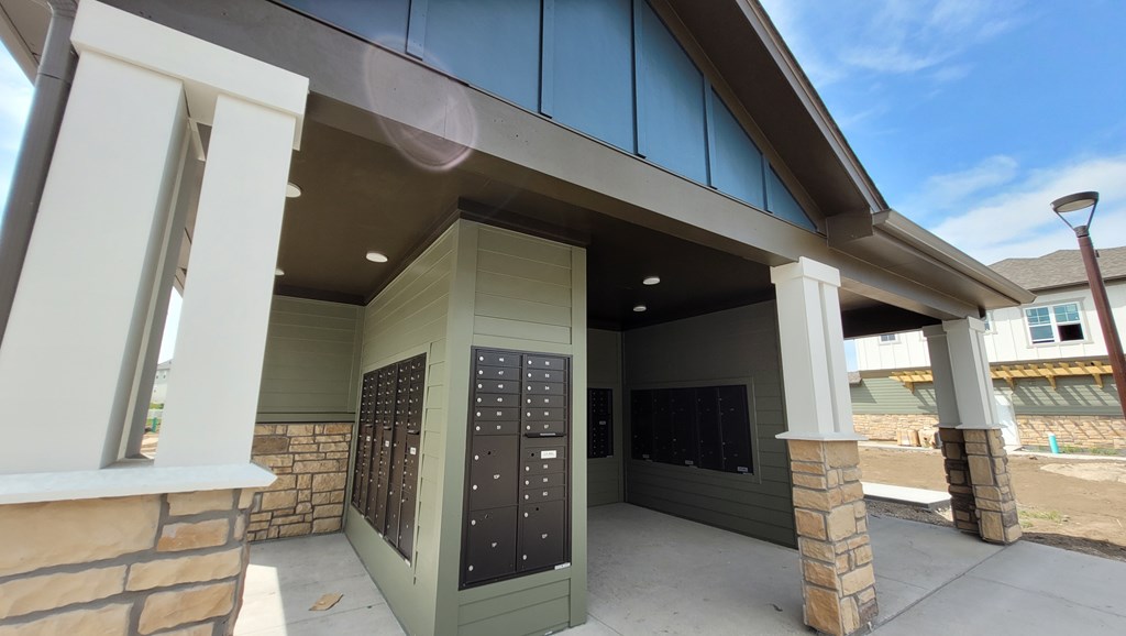 A building with a grey roof and a black mailbox.