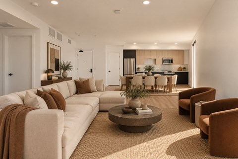 A living room with a white couch and brown pillows.
