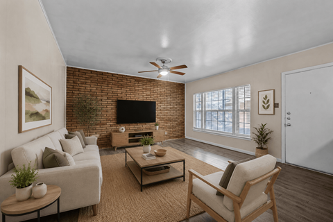 A living room with a couch, chair, and a television.