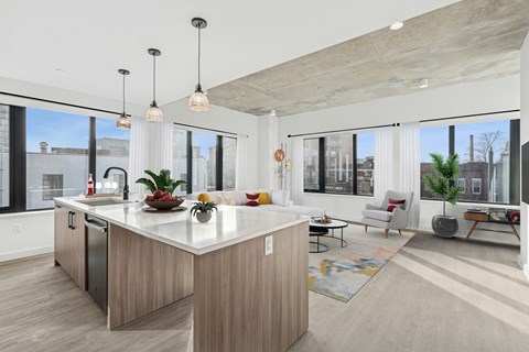 A modern kitchen with a large island and a dining area.
