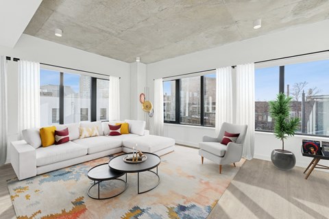A modern living room with a white sofa, a coffee table, and a large window.