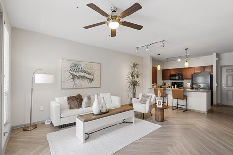 A living room with a white couch and a ceiling fan.
