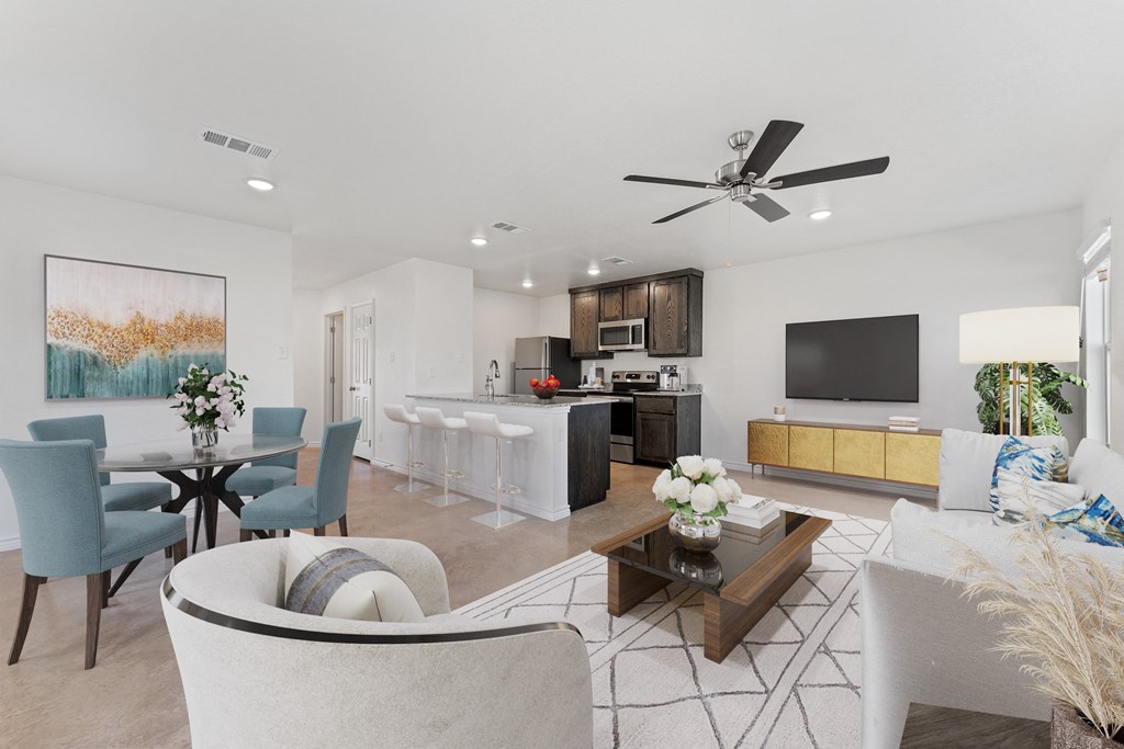 a living room with couches and chairs and a kitchen with a tv