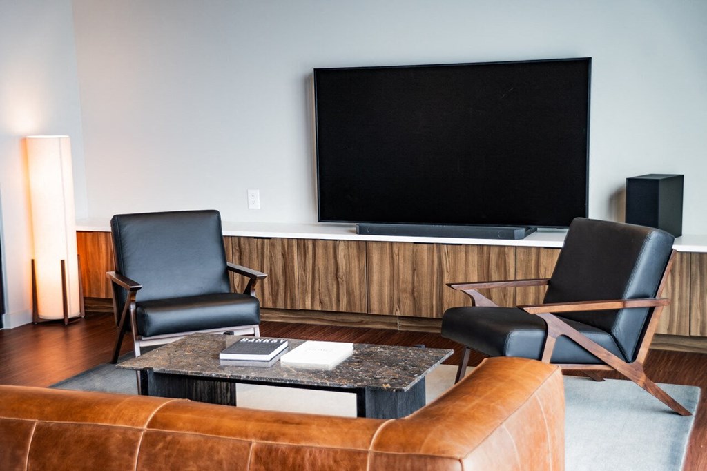 a living room with a couch and chairs and a television