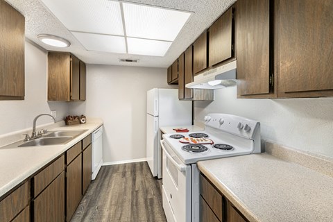 A kitchen with a white stove top oven and a white refrigerator.