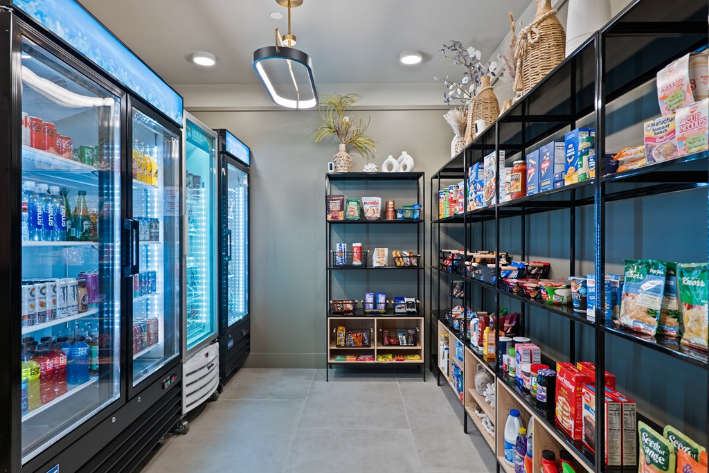 A convenience store shop with a glass door and a shelf with snacks and drinks.