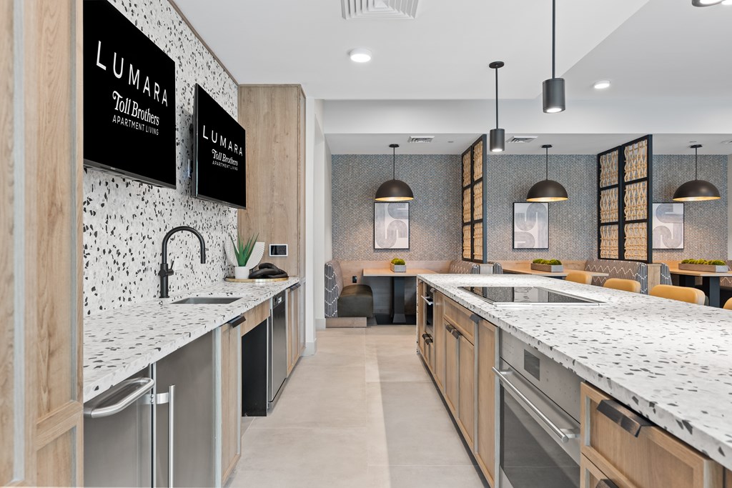 A modern kitchen with a countertop and a wall with a black and white speckled design.