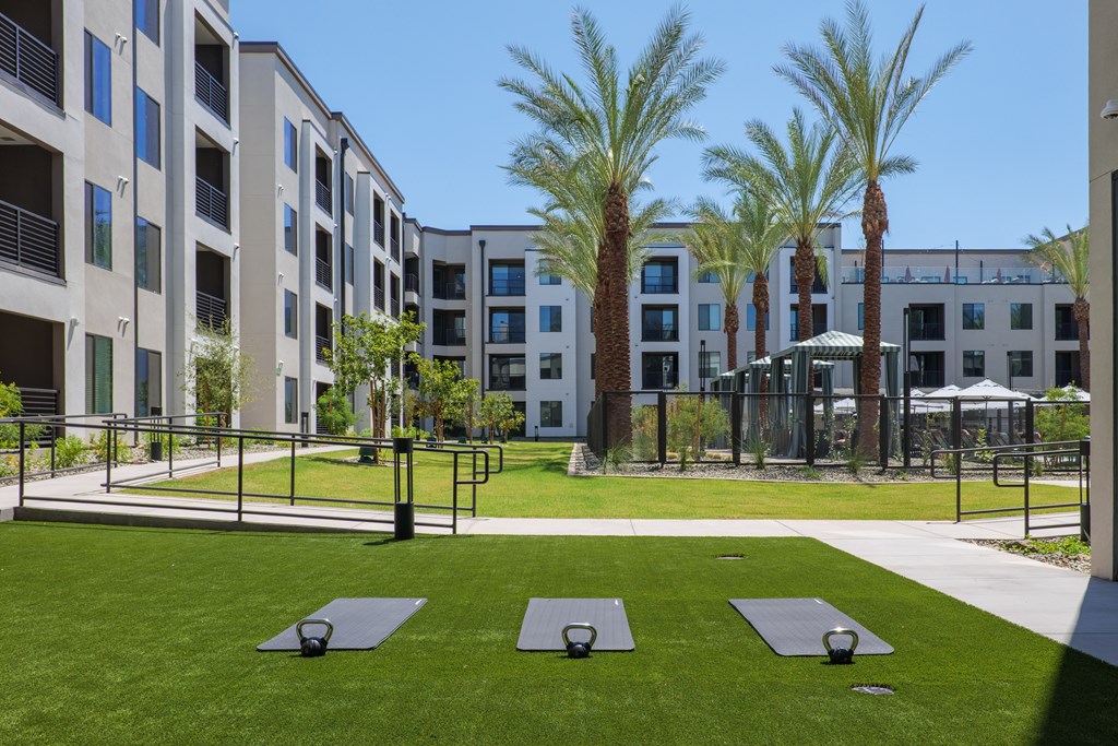 A yoga mat is on the grass in front of a building.