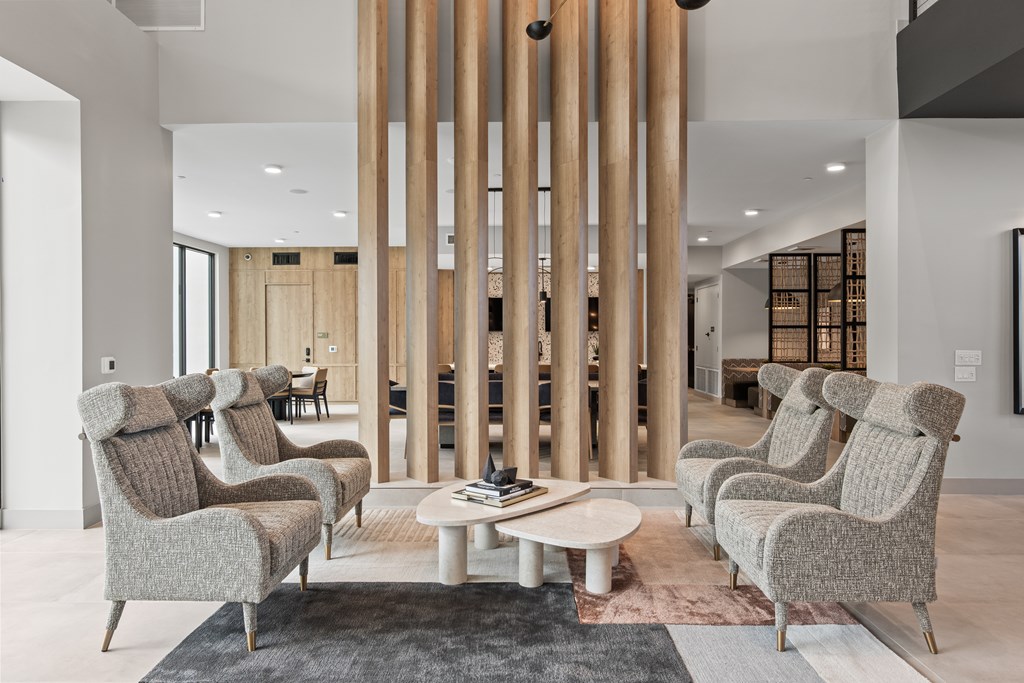 A room with a long column and chairs around a table.