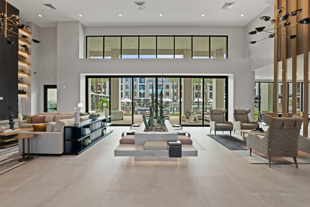 A spacious living room with a large window, a coffee table, and a variety of seating options.