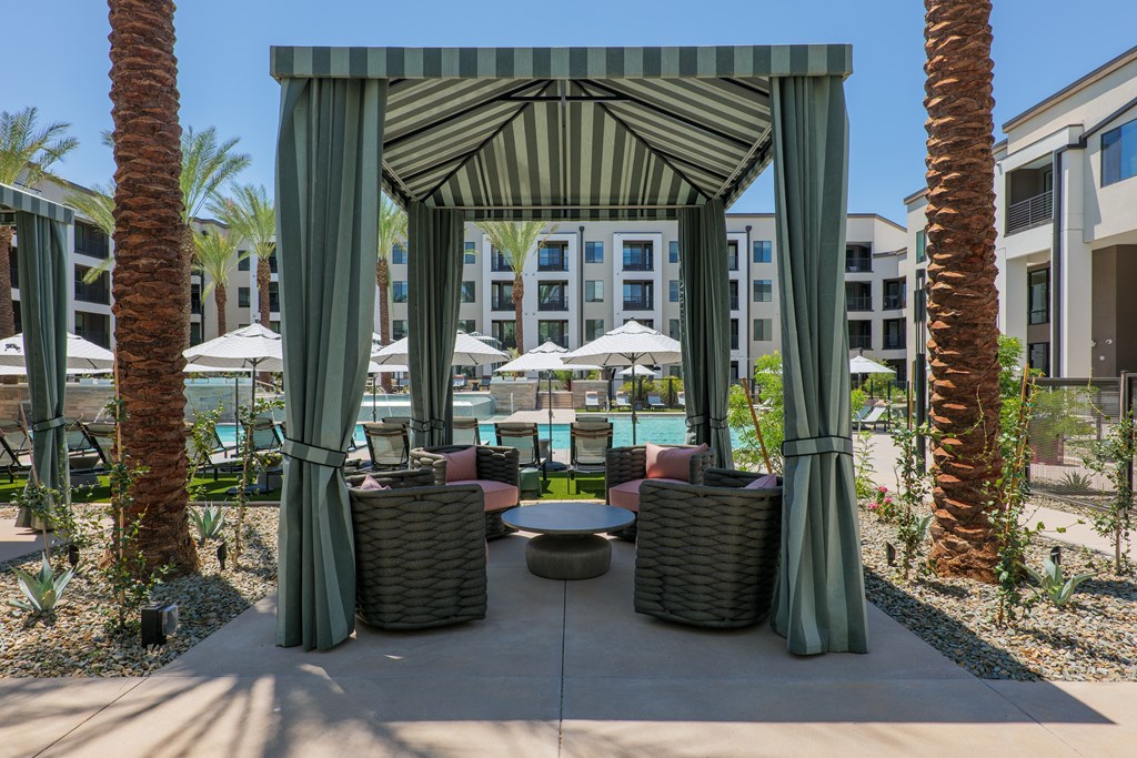 A patio area with a canopy and wicker furniture.