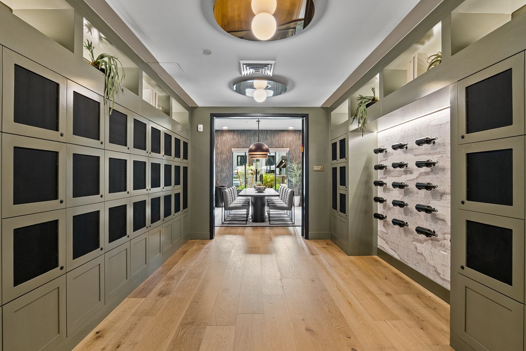 A long hallway with a row of cabinets on the left and a row of wine lockers on the right.