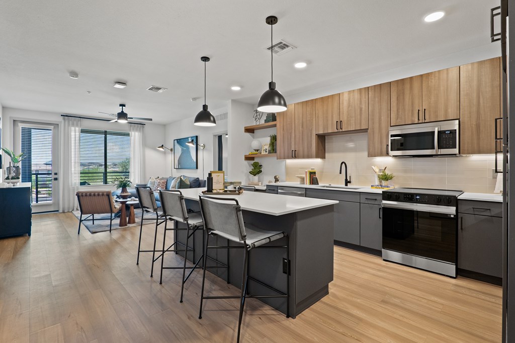 A modern kitchen with wooden cabinets and a large island.
