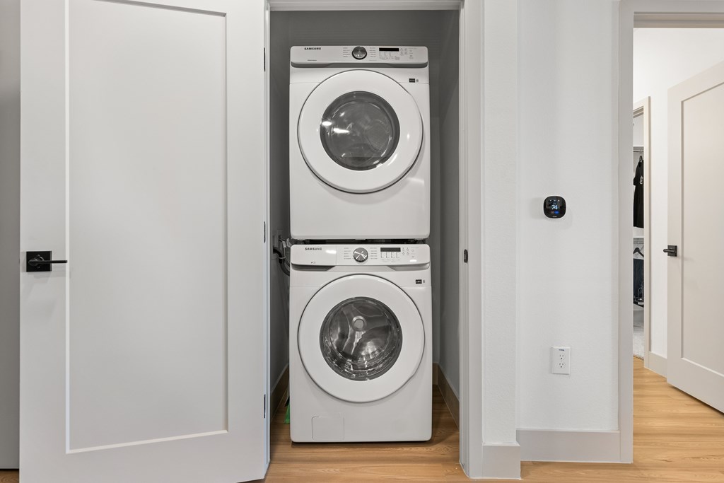 A white door is open to a laundry room with a washer and dryer.