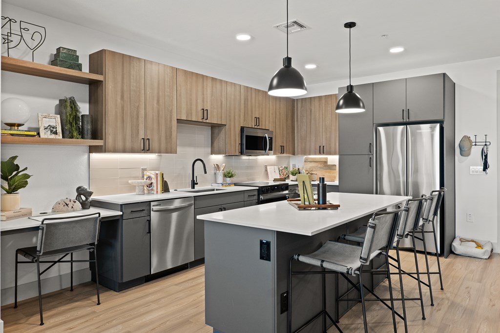 A modern kitchen with a large island and stainless steel appliances.