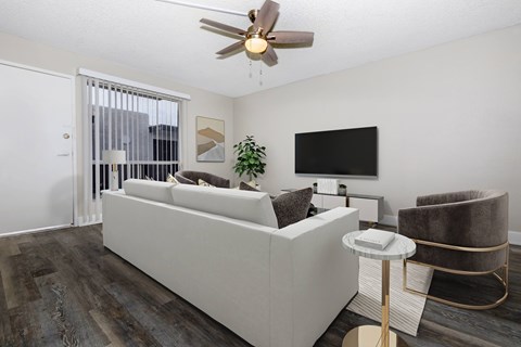 A living room with a white couch and a ceiling fan.