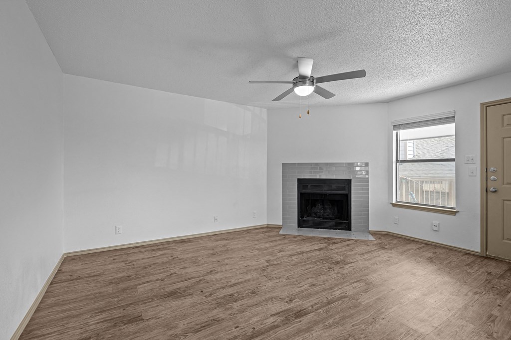 A room with a fireplace and a ceiling fan.