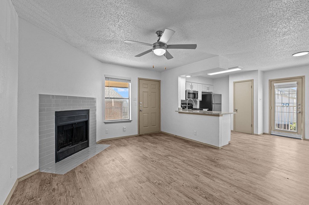 A living room with a fireplace and a ceiling fan.