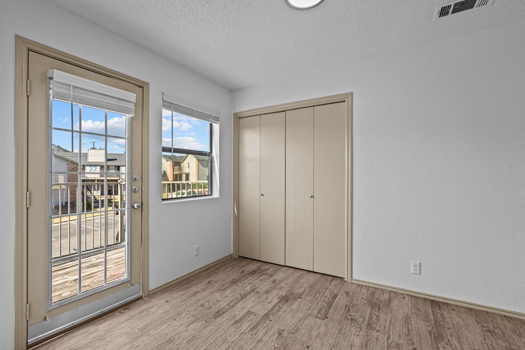 A room with a door, a window, and a wall-mounted cabinet.