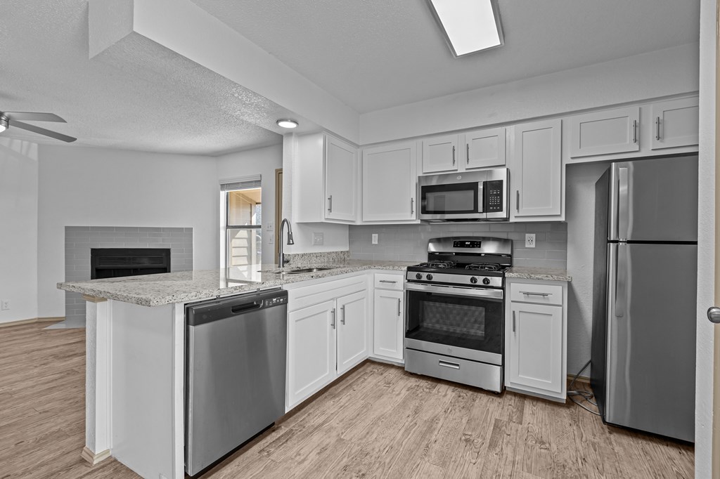 A kitchen with white cabinets and stainless steel appliances.