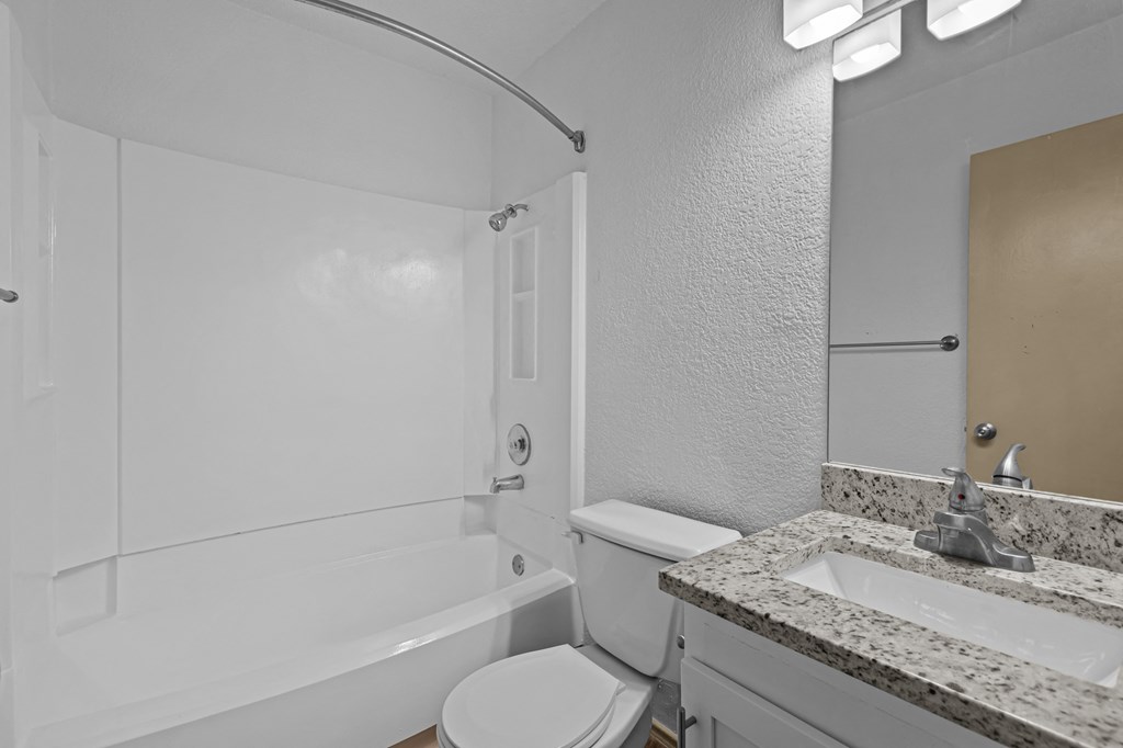 A white bathroom with a toilet, sink, and bathtub.