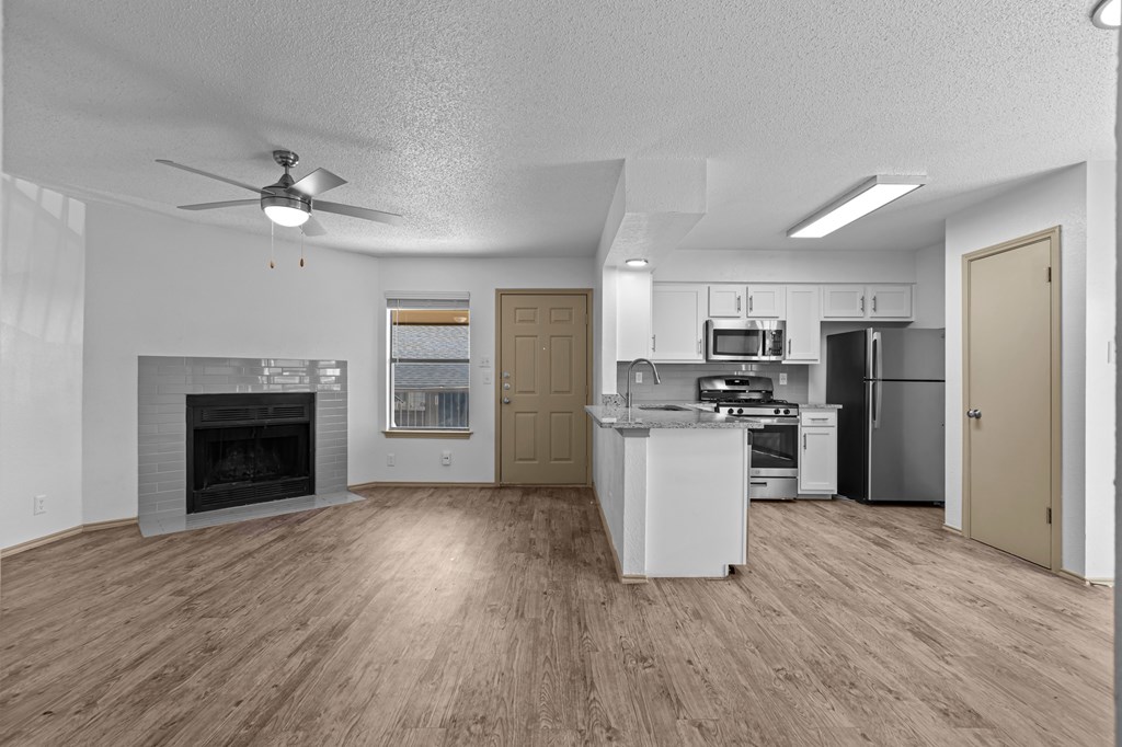 A spacious kitchen with a fireplace and a refrigerator.