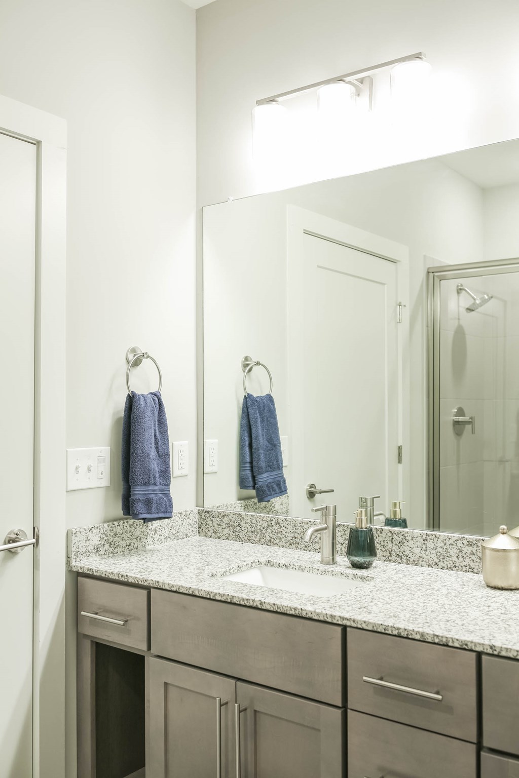 A bathroom with a sink, mirror, and towel rack.