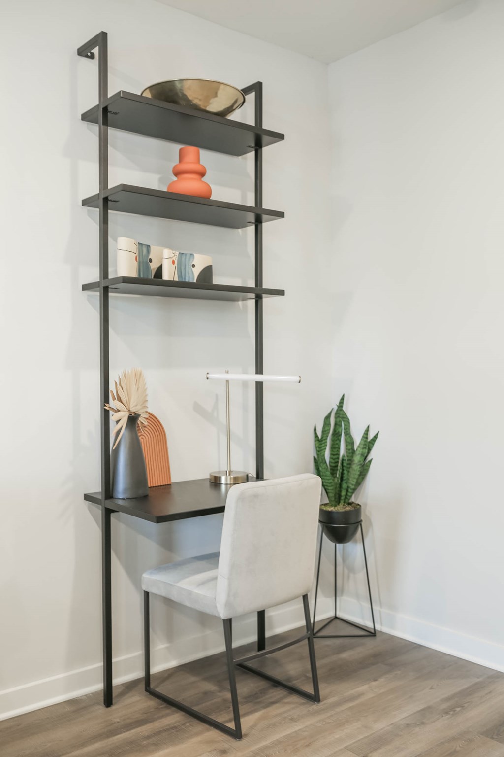 A black shelf with a chair and a potted plant.