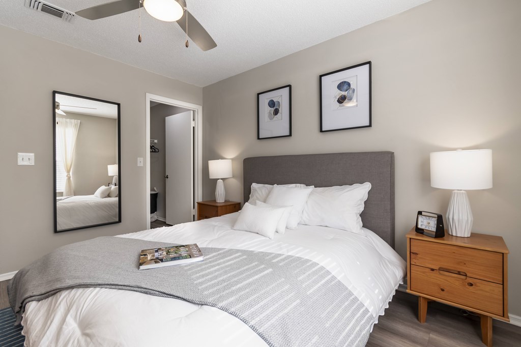 A bedroom with a large bed and a ceiling fan.