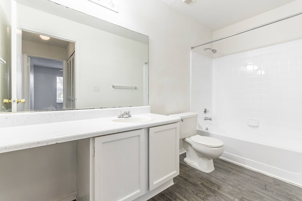 A white bathroom with a toilet, sink, and bathtub.