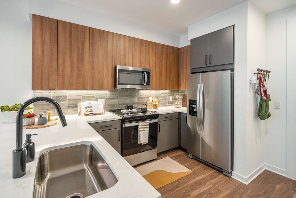 A modern kitchen with a stainless steel refrigerator and wooden cabinets.