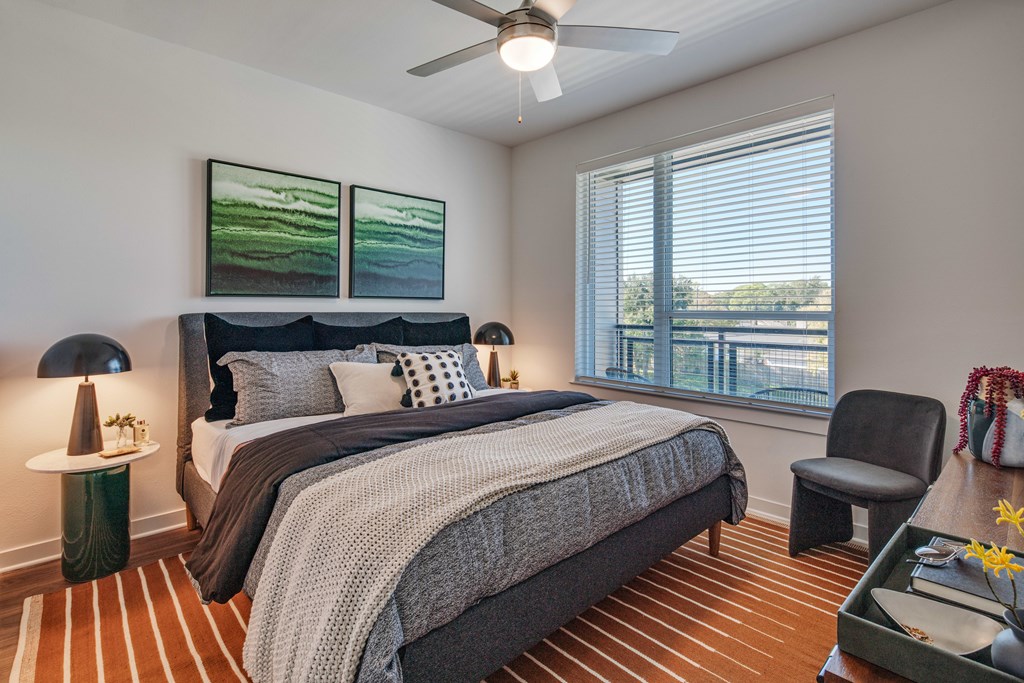 A bedroom with a large bed and a ceiling fan.